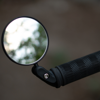 Lightweight helmet-mounted mirror with adjustable polycarbonate lens and rubber strap for commuter safety