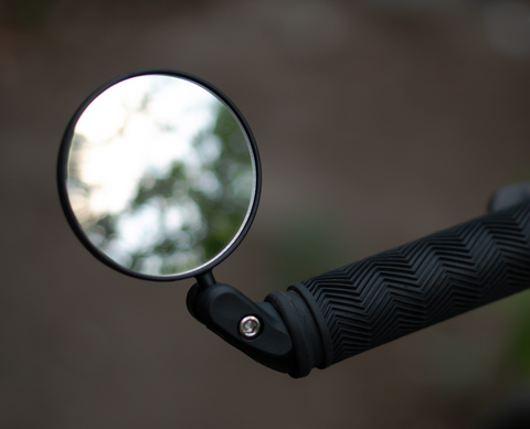 Lightweight helmet-mounted mirror with adjustable polycarbonate lens and rubber strap for commuter safety