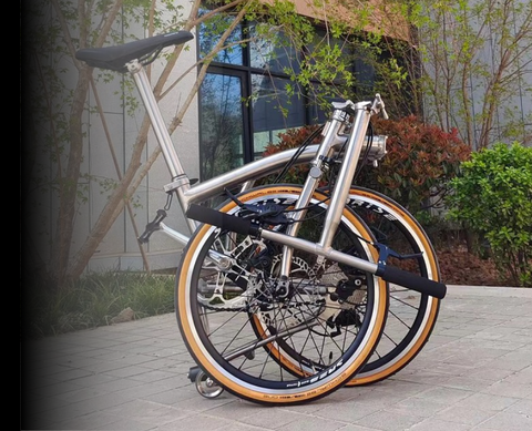 Compact folding bike frame with aluminum hinge joint and 20" wheels for urban commuting