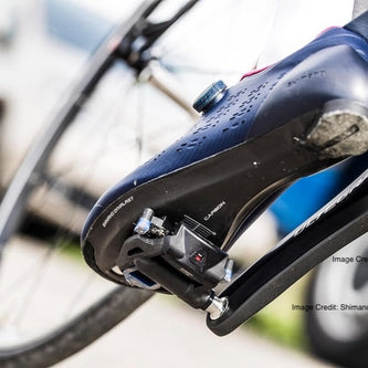 Cyclist aggressively pedaling with clipless shoes locked into mountain bike pedals for stability