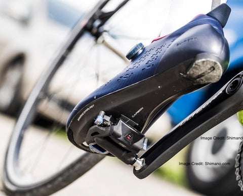 Cyclist aggressively pedaling with clipless shoes locked into mountain bike pedals for stability