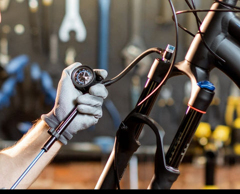 Dial adjustments on fork crown: rebound damping and lockout lever for climb/descent tuning