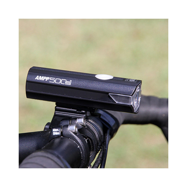 The AMPP500s front bike light mounted on a handlebar, providing consistent LED illumination for enhanced safety during night-time rides.