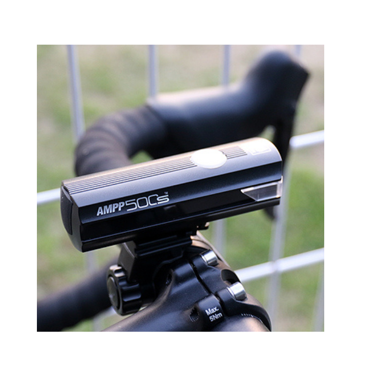 The AMPP500s front bike light mounted on a bicycle handlebar, featuring powerful LED technology for enhanced night-time visibility and cycling safety.