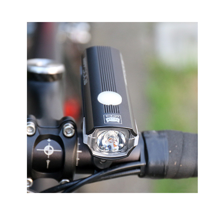 AMPP500s front bike light with a bright LED beam, mounted on a bicycle's handlebar, providing clear visibility during night cycling.