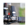 AMPP500s front bike light with a bright LED beam, mounted on a bicycle's handlebar, providing clear visibility during night cycling.