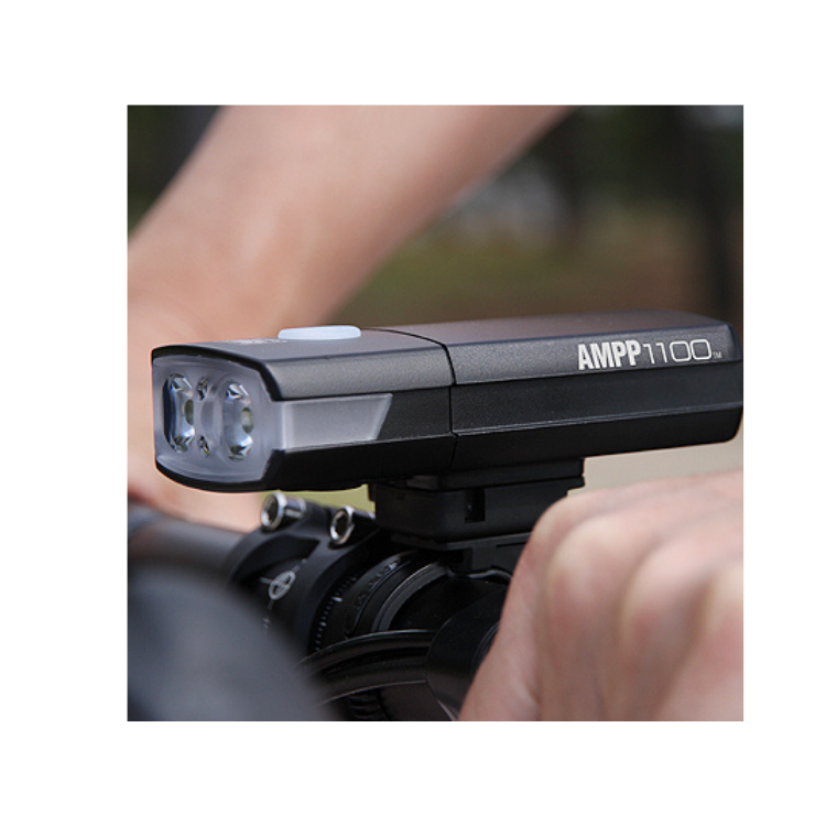 Cateye AMPP1100 front bike light mounted on handlebars, offering long-lasting illumination for cycling in dark environments.
