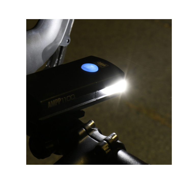 Cateye AMPP1100 bike light illuminating during a night ride, providing bright and clear lighting for safety on dark paths.