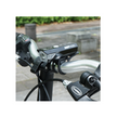 Cateye AMPP 100 bike headlight mounted on a handlebar, providing clear illumination for night cycling, with a close-up view of its mounting system.