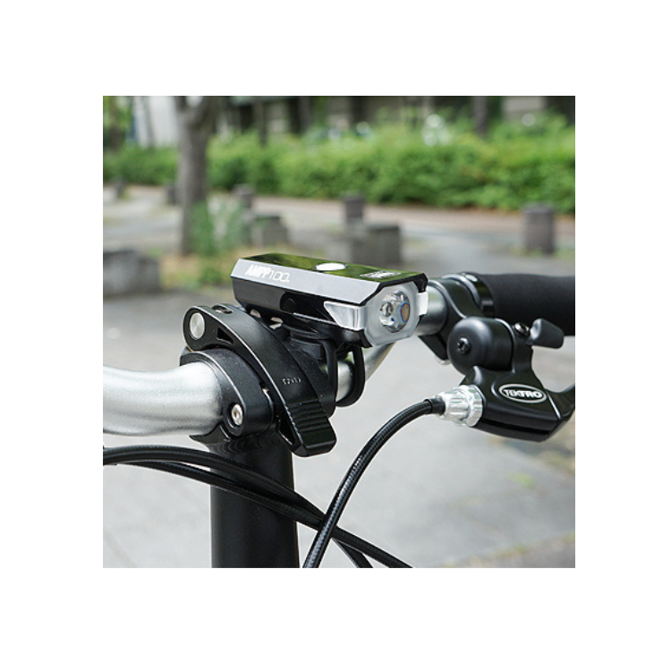 Cateye AMPP 100 headlight mounted on the front handlebars of a bike, designed for optimal illumination during cycling in low-light conditions.