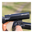 Cateye AMPP 2200 front bike light illuminated on a handlebar during daylight