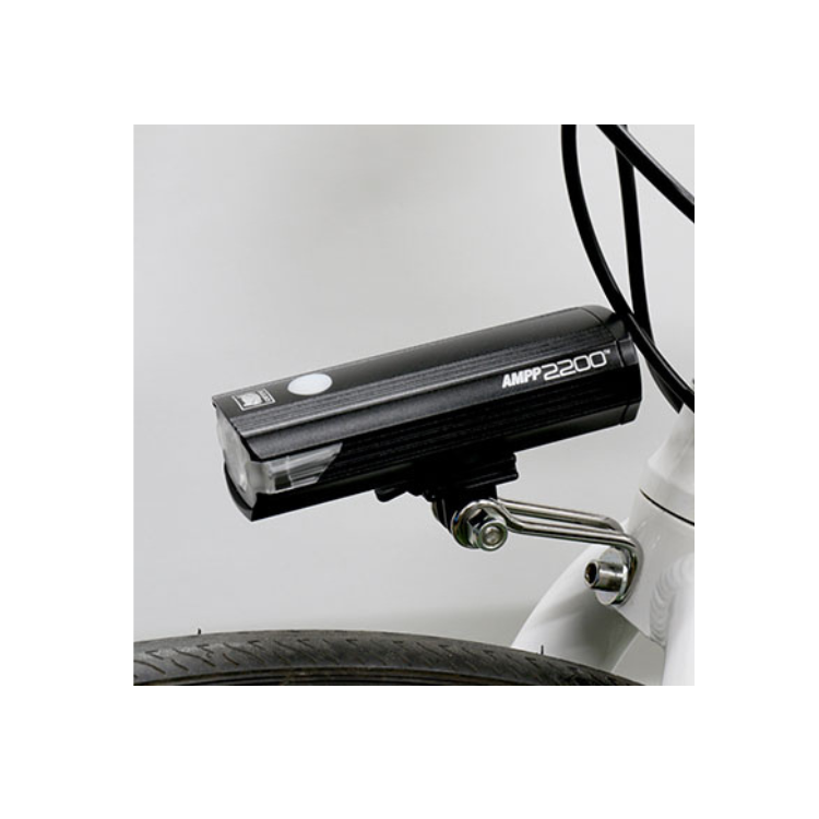 Cateye AMPP 2200 front bike light mounted on a bicycle, providing powerful LED illumination to enhance night-time visibility for cyclists.