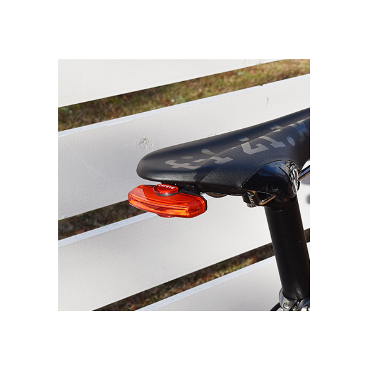 Cateye rear light securely mounted on the seat post of a bicycle, providing enhanced visibility for cycling in low-light conditions.