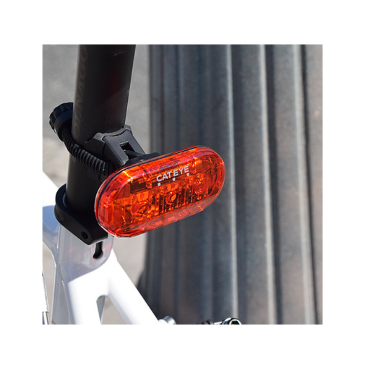 Cateye rear LED bike light mounted on a bike seat post, showing its bright red light for improved visibility during cycling.