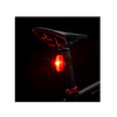 Cateye VIZ150 red rear bike light mounted on a bicycle seat post glowing brightly in a dark setting.