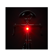  Cateye VIZ150 rear bike light with red LED on a bike saddle, glowing brightly in low light.