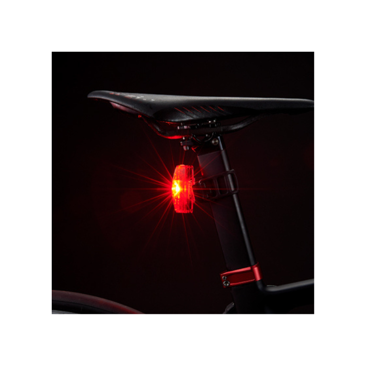  Cateye VIZ150 rear bike light with red LED on a bike saddle, glowing brightly in dark settings.