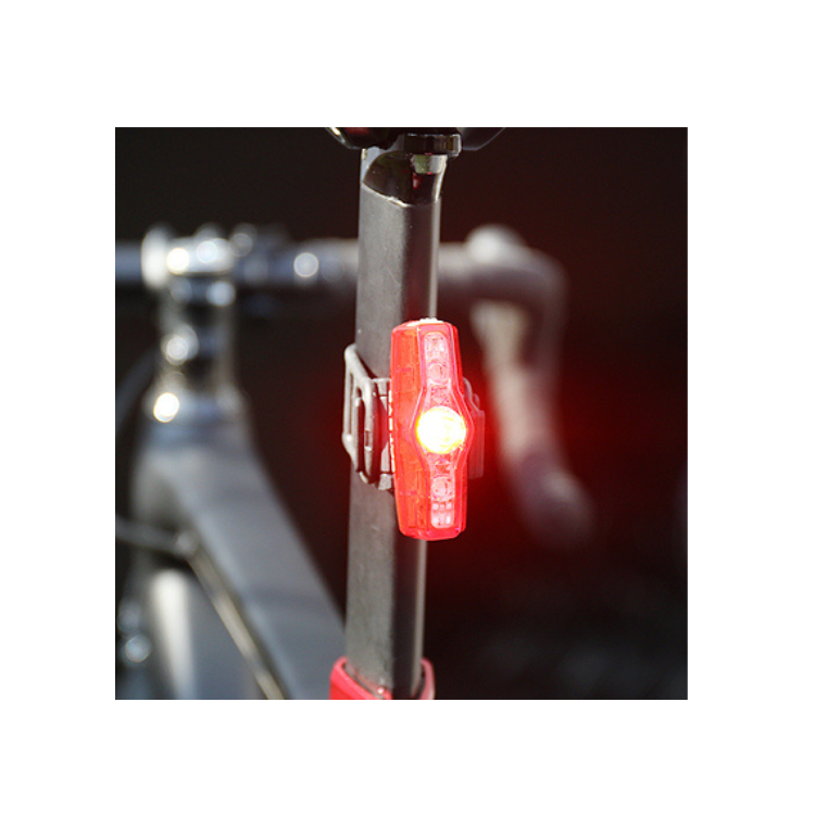Cateye VIZ 150 rear light mounted on a bicycle seat post, emitting bright red light for increased safety and visibility during cycling at night.