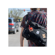 Cateye wearable mini LED light attached to a backpack, providing extra visibility for cyclists or pedestrians in low-light conditions.