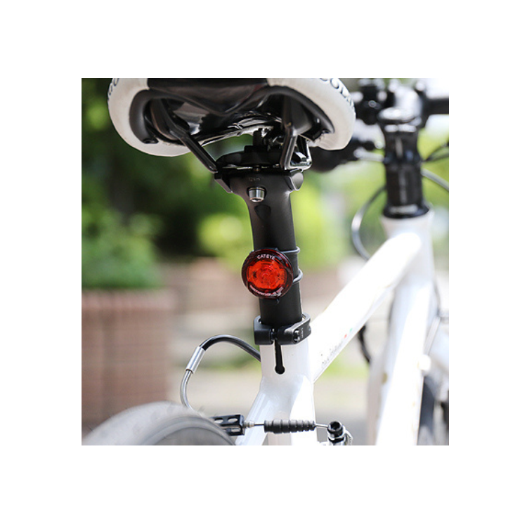 Cateye wearable LED light mounted on a bike seat post, providing bright red visibility for enhanced safety during cycling.