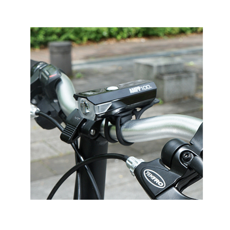 Close-up of Cateye AMPP 100 front bike light, showcasing the power button and advanced lighting design.
