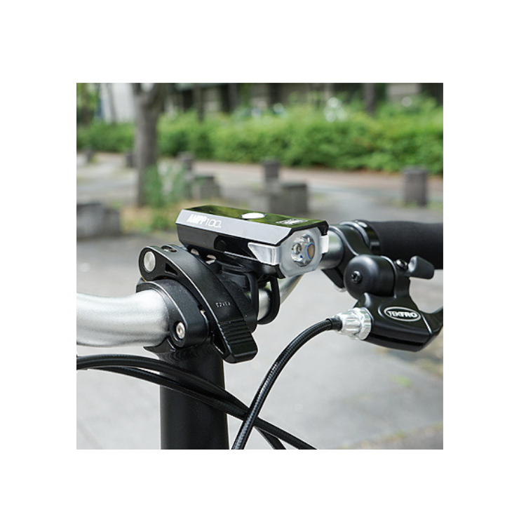 Cateye AMPP 100 front bike light mounted on handlebars, designed for clear visibility during cycling.