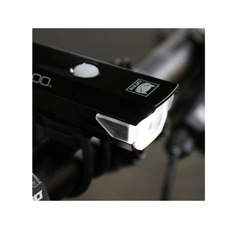 Cateye AMPP 100 front bike light mounted on handlebars, offering optimal brightness in an outdoor setting.