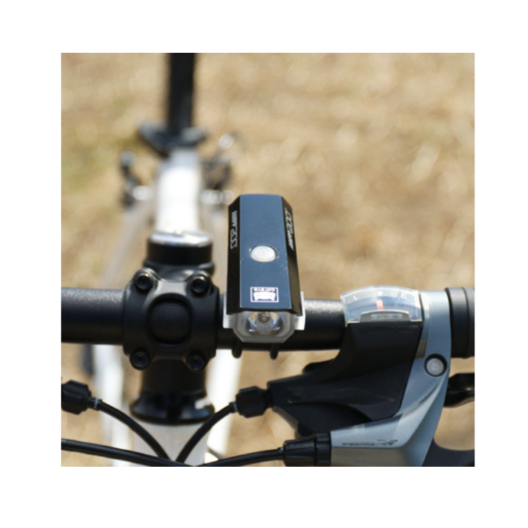 Close-up of Cateye AMPP 200 front bike light showing the power button and lens.