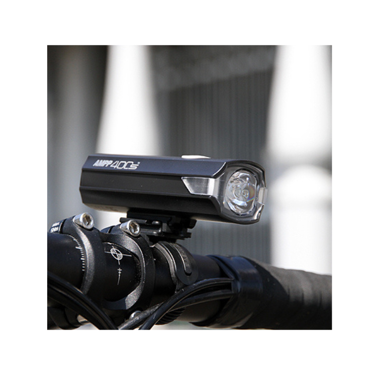 Cateye AMPP 400s front bike light mounted on handlebars, offering a wide beam for enhanced night visibility.