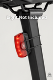 Red bicycle tail light attached to a black bike frame on a white background