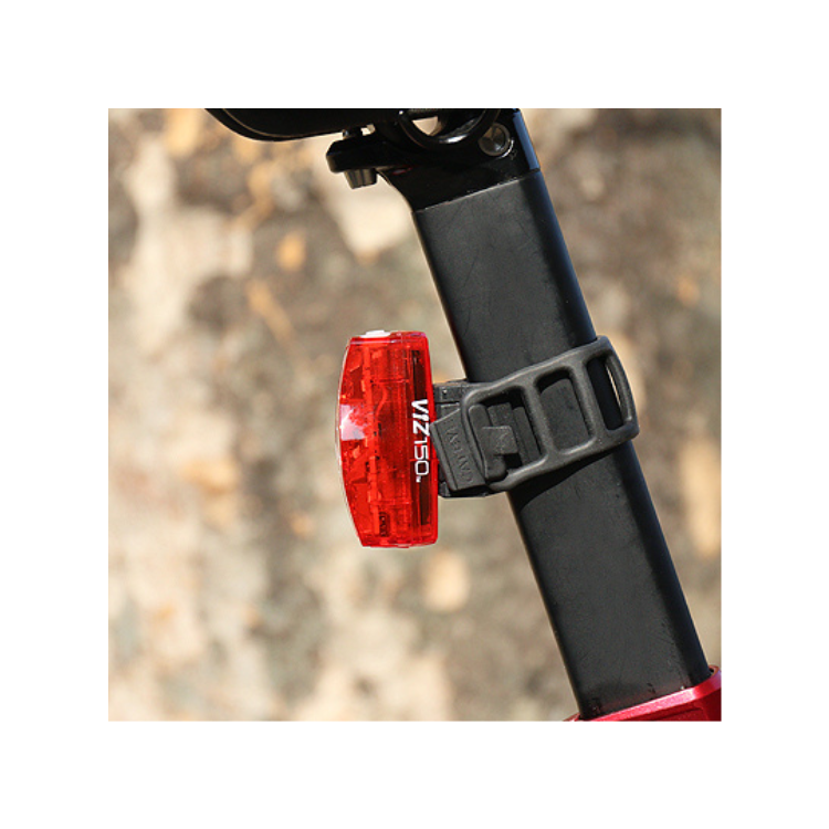 Close-up view of Cateye VIZ150 rear bike light attached to the seat post of a bike, featuring red LED lights for safety.