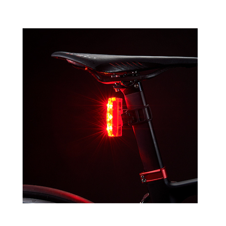 Cateye VIZ300 rear light glowing in dark conditions to ensure visibility and safety during nighttime cycling.
 