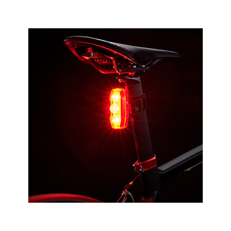 Cateye VIZ300 rear light emitting bright red light for enhanced visibility in dark conditions.