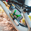 Silver and rainbow Lezyne Pocket Drive Pro mini pump mounted securely on a mountain bike frame alongside a water bottle.