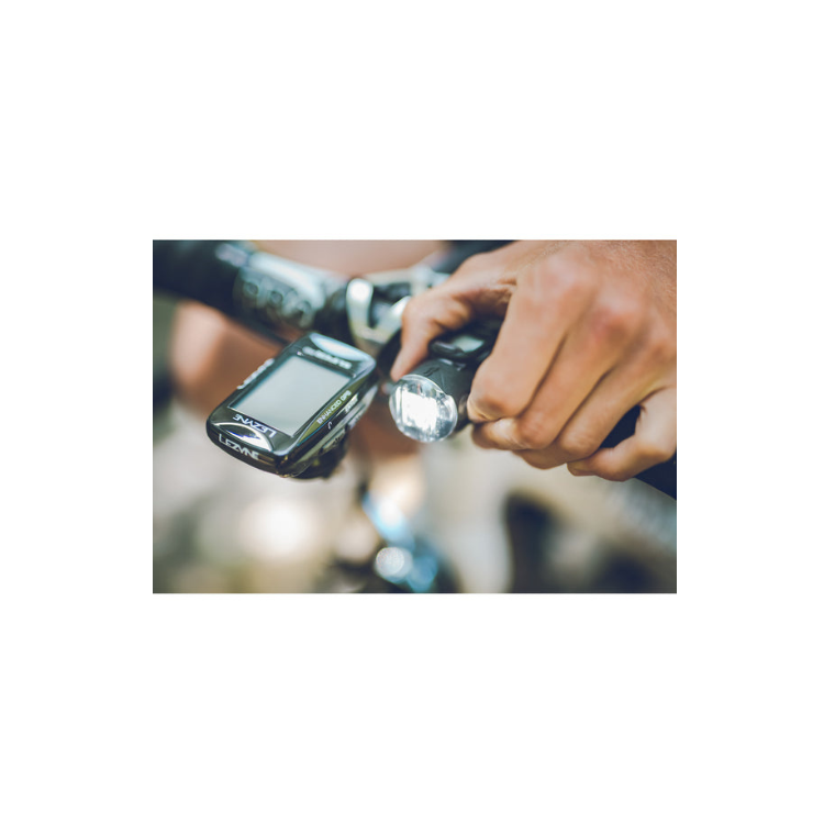 Lezyne front bike light being activated by a cyclist, mounted on the handlebar for enhanced night riding visibility and safety.