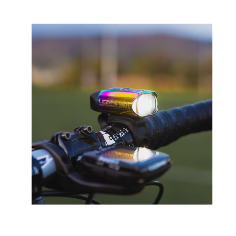 Lezyne Hecto Drive 500XL front bike light in rainbow finish, mounted on the handlebar with a bright LED for enhanced night visibility.