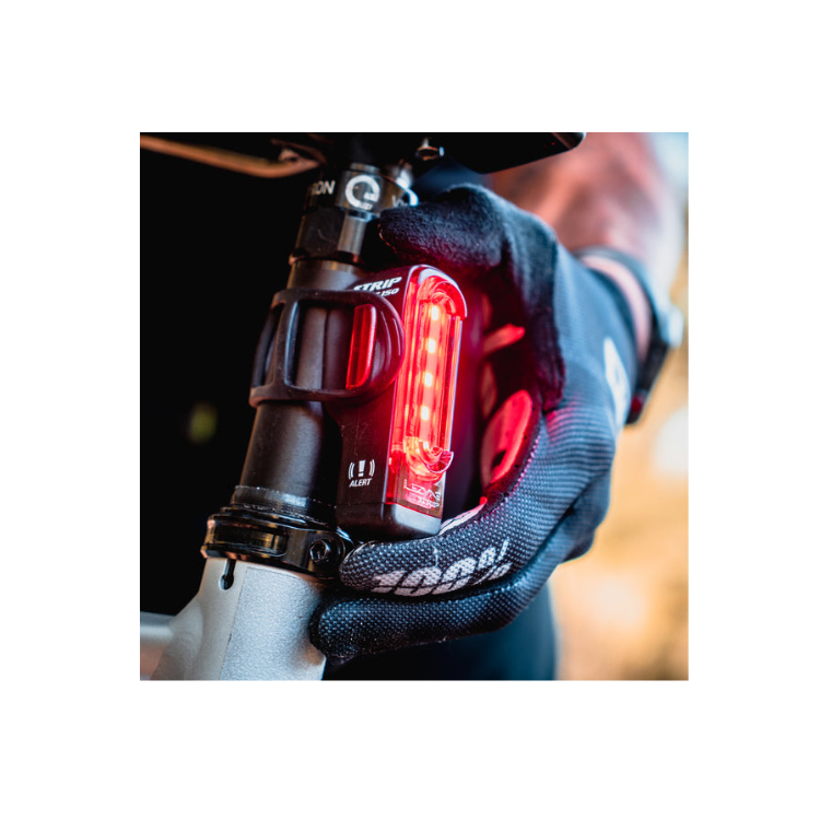 Lezyne Strip 150 rear bike light with alert mode, being installed on the bike, visible red LED lights for increased safety.