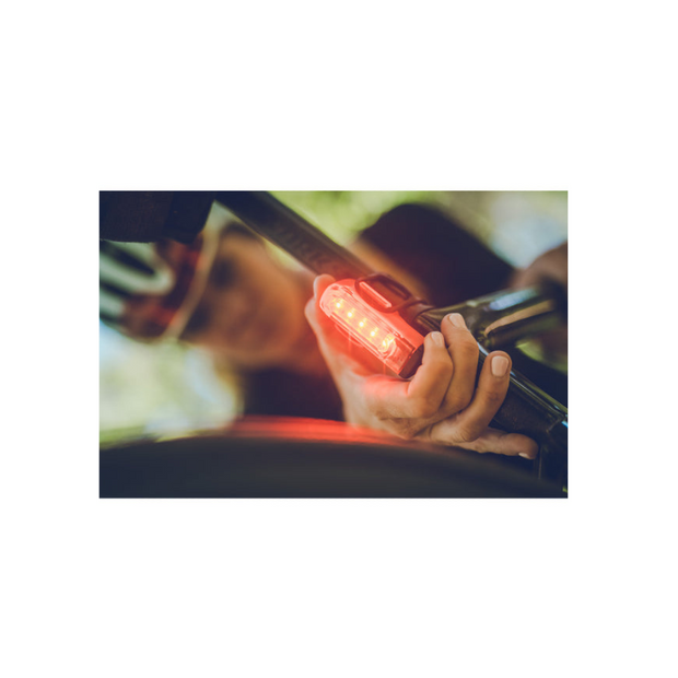 Lezyne Strip Pro rear bike light being installed on a bike, featuring bright red LEDs for visibility and safety.