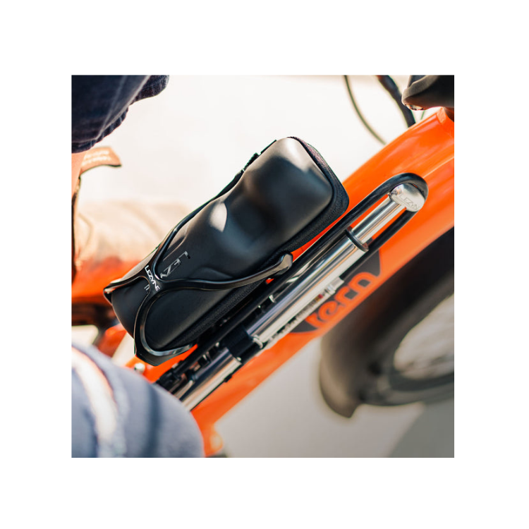 Black Lezyne bottle cage holding a tool kit securely mounted on an orange bicycle frame.