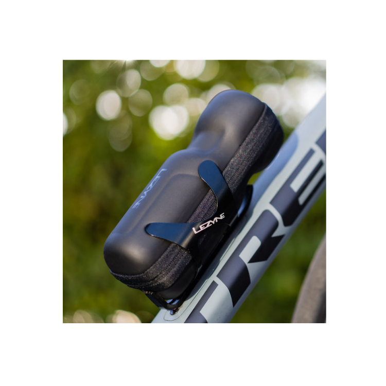 Black Lezyne bottle cage securely holding a tool kit pouch on a grey Trek bicycle.