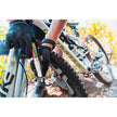Cyclist wearing gloves using a Lezyne Pocket Drive Pro pump to inflate a mountain bike tire on a trail.