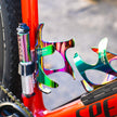 Close-up of a Lezyne Pocket Drive Pro mini pump in oil-slick finish attached to a red bike frame with rainbow bottle cages.