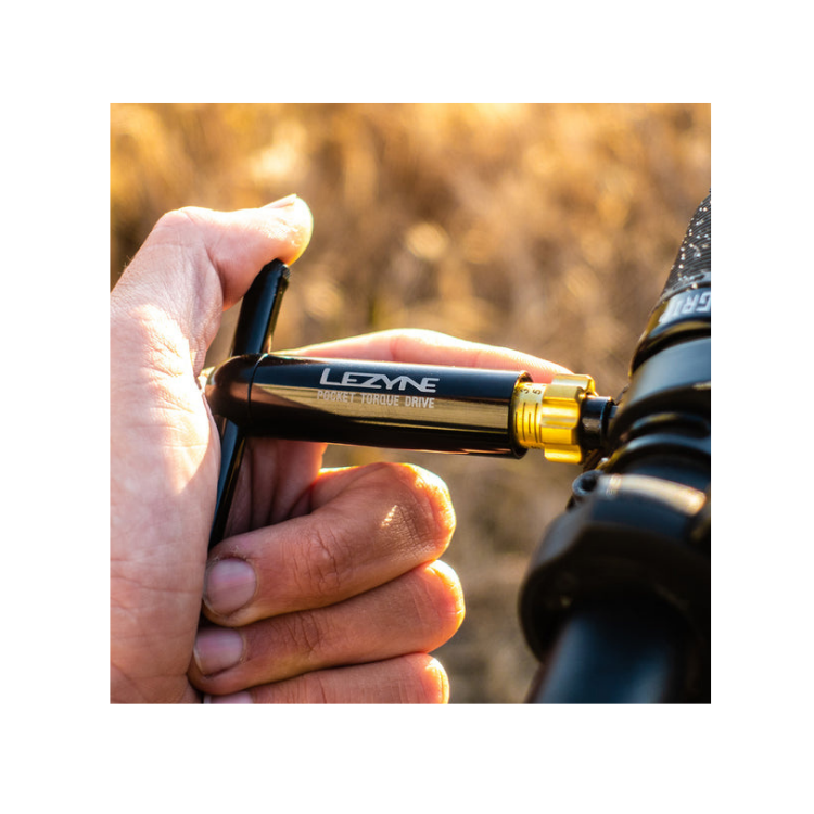 Rider tightening bicycle stem bolt with Lezyne Pocket Torque Drive tool.