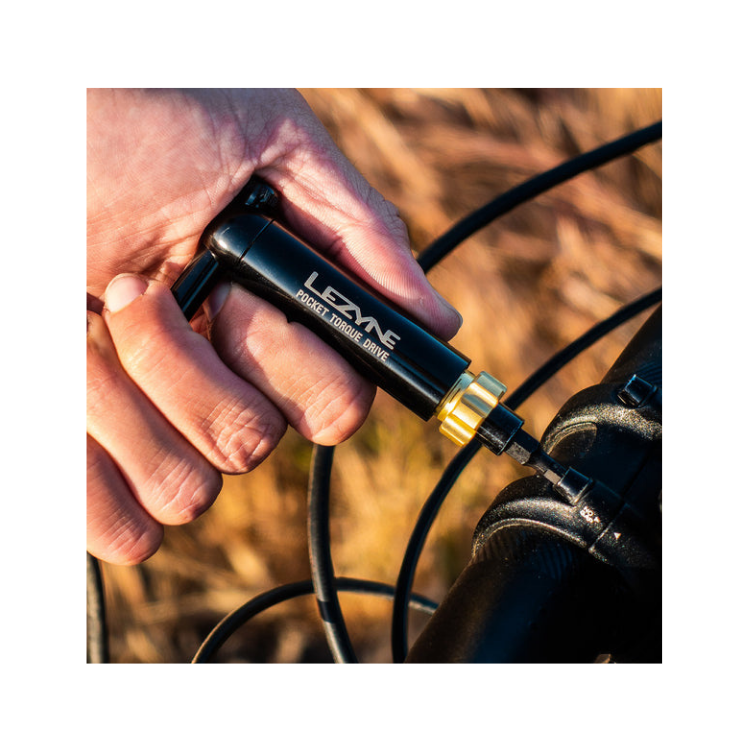 Cyclist using Lezyne Pocket Torque Drive tool to tighten bike handlebar bolt.