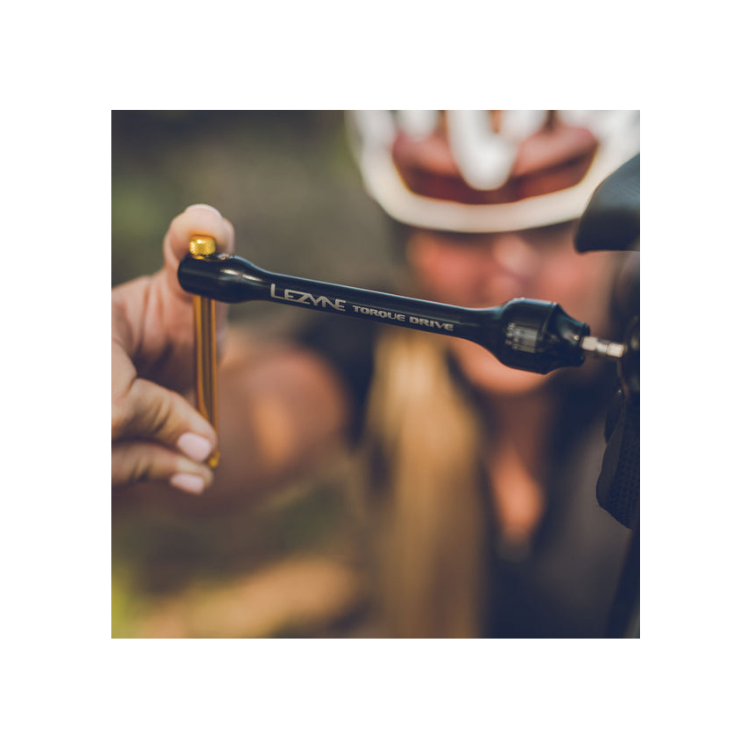 Cyclist using the Lezyne Torque Drive wrench during a trail-side adjustment.