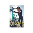 Cyclist adjusting a Lezyne-equipped bike on a rugged mountain trail.