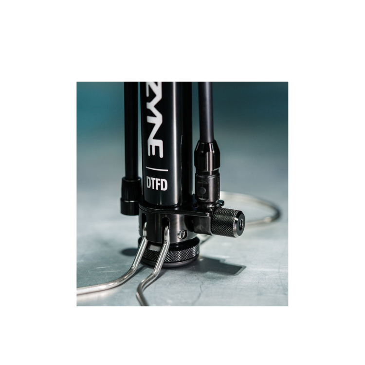 Detailed shot of the metal base and foot supports of a bicycle floor pump for added stability during use.