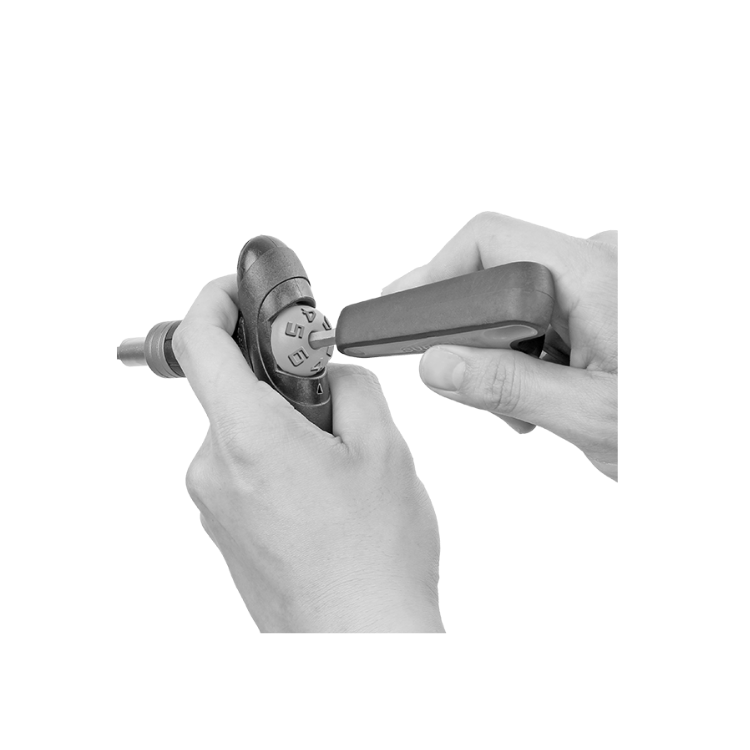 Hands adjusting the torque setting dial on a Super B torque wrench.