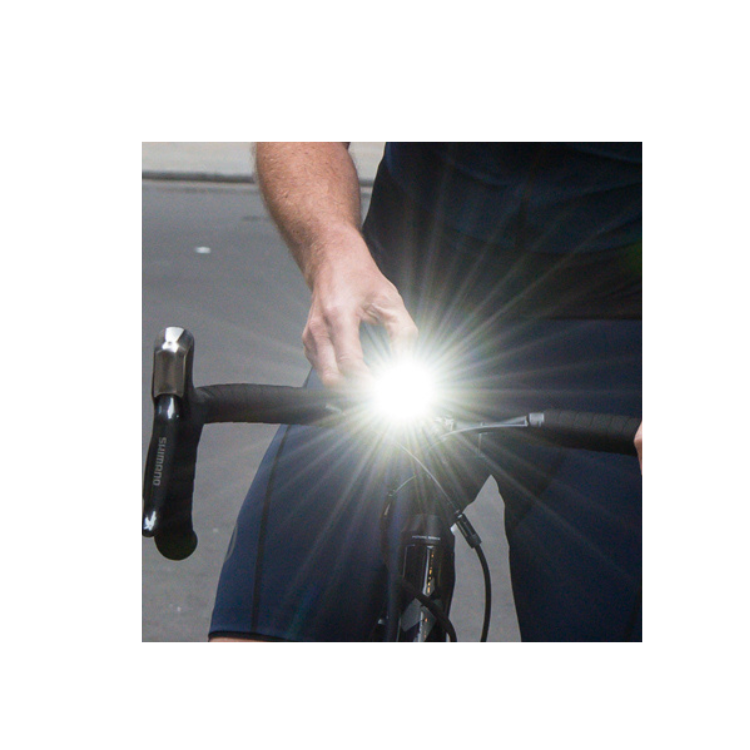 Sync Core Bicycle Front Light in Use - A cyclist adjusting the Sync Core front bike light for improved nighttime visibility and safety on the road.