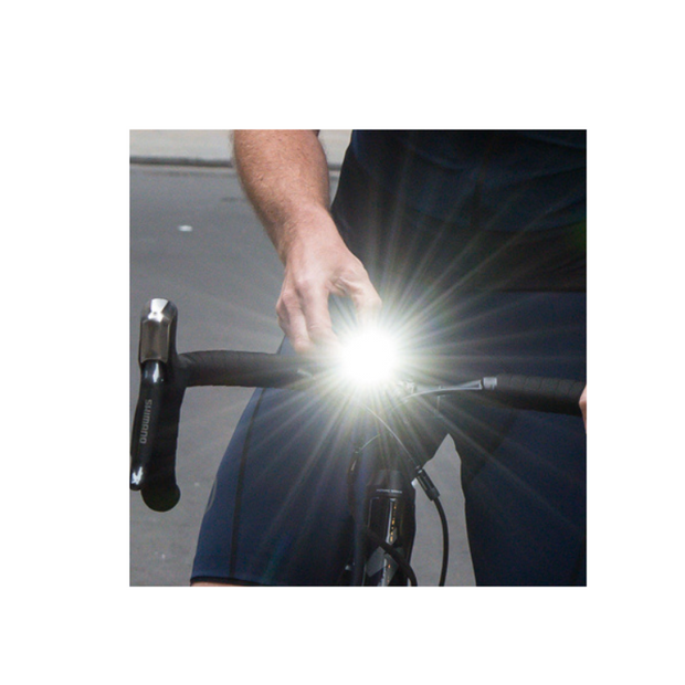 Sync Core Bicycle Front Light in Use - A cyclist adjusting the Sync Core front bike light for improved nighttime visibility and safety on the road.